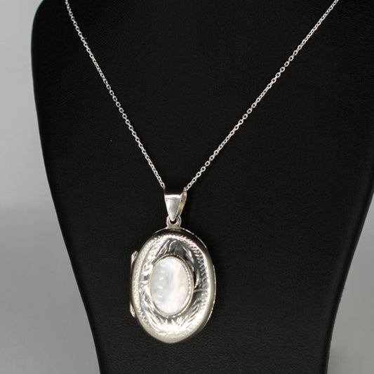 Oval shaped embellished silver photo locket necklace with white mother of pearl inlay on Italian silver chain displayed on black bust.