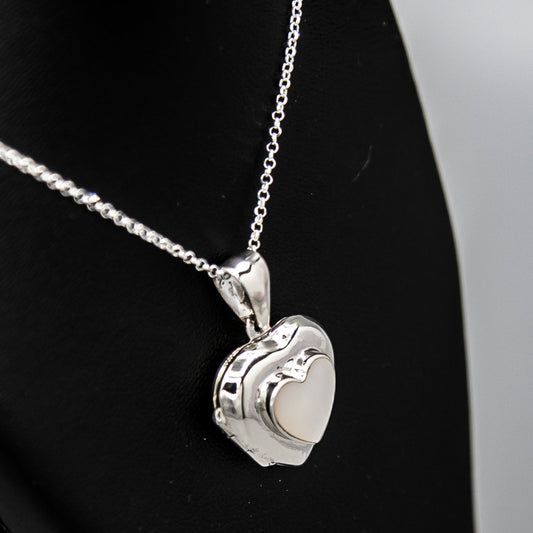 Silver heart shaped photo locket pendant with white mother of pearl inset with a silver Italian chain displayed on a black bust.
