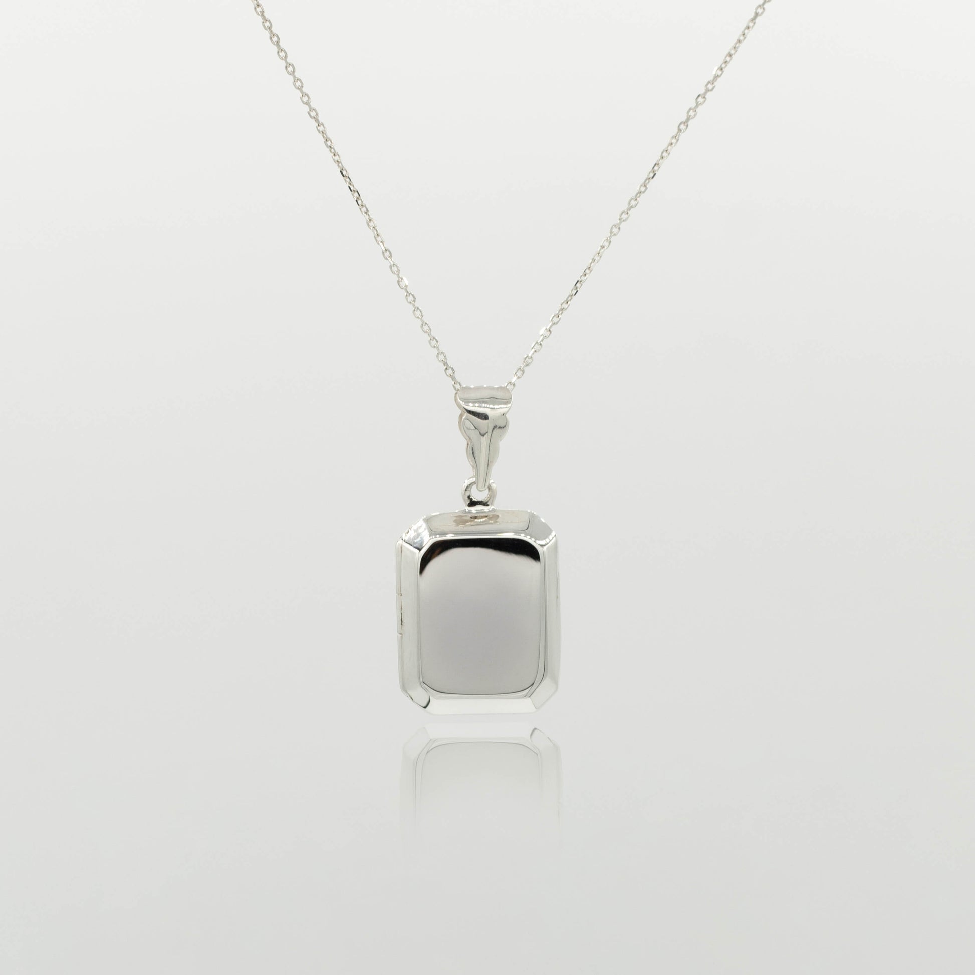 rectangular silver locket on a fine silver chain with a white background