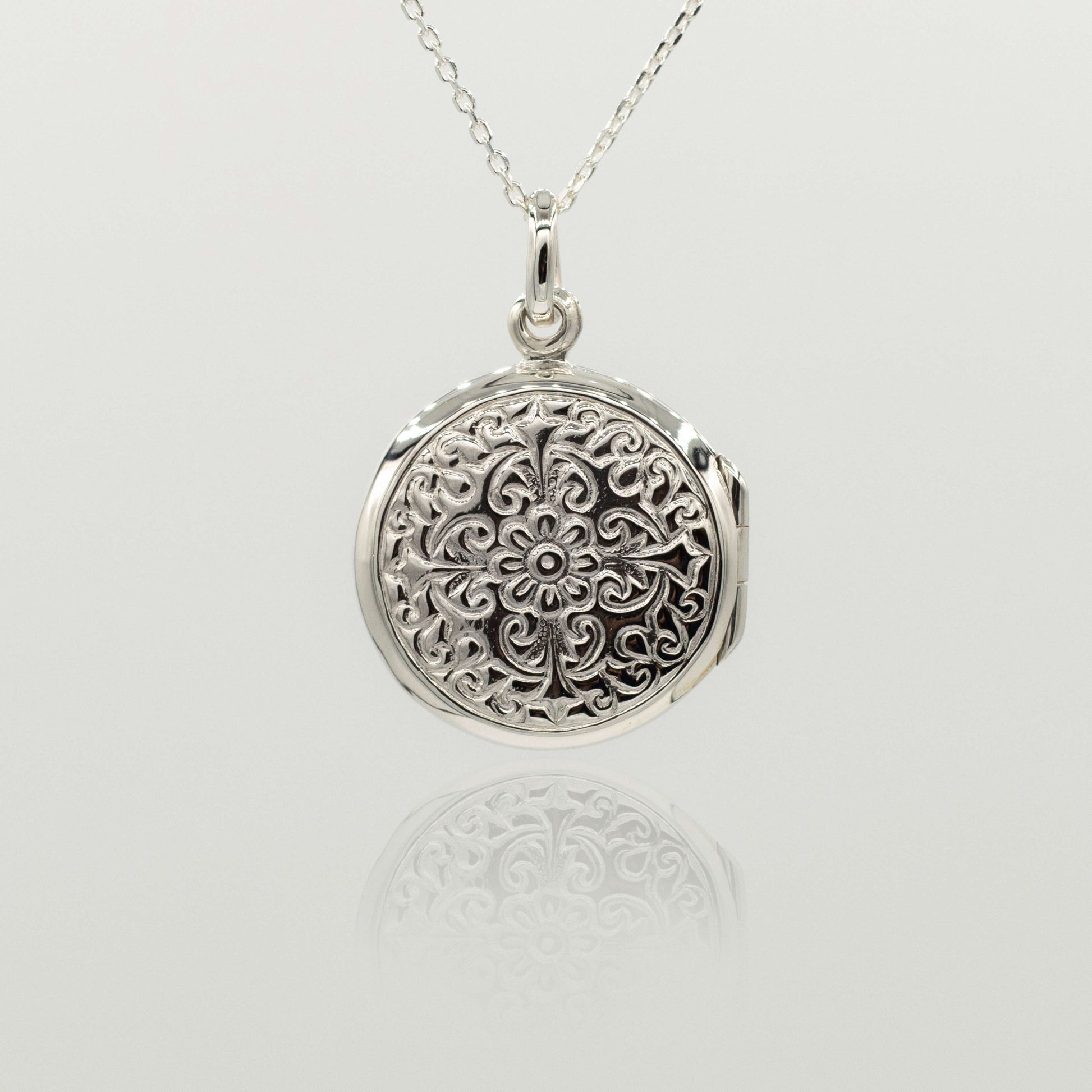sterling silver ornate round shaped locket with intricate design close up