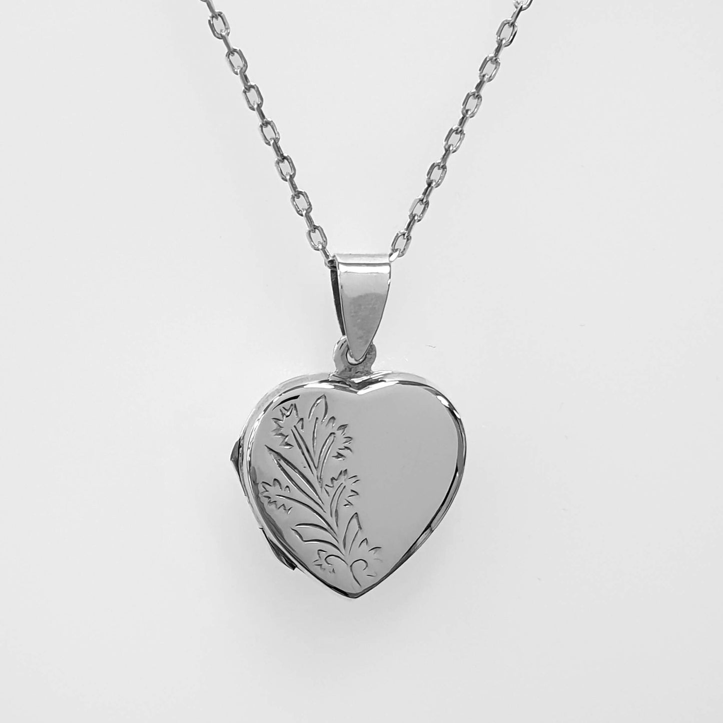 Heart shaped double photo locket in sterling silver on a white background