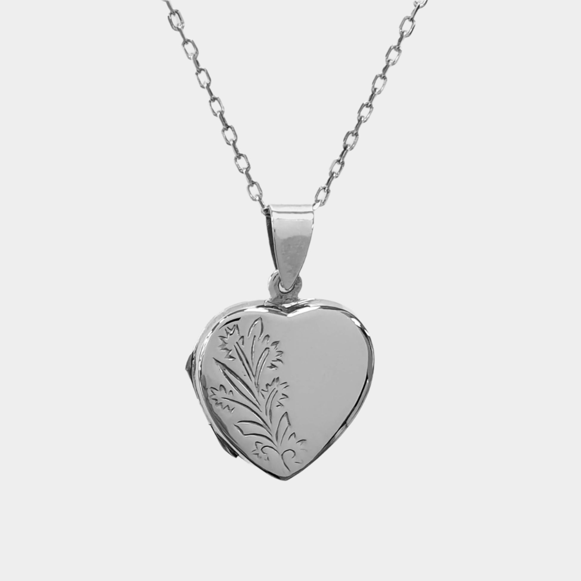 Heart shaped double photo locket in sterling silver on a white background