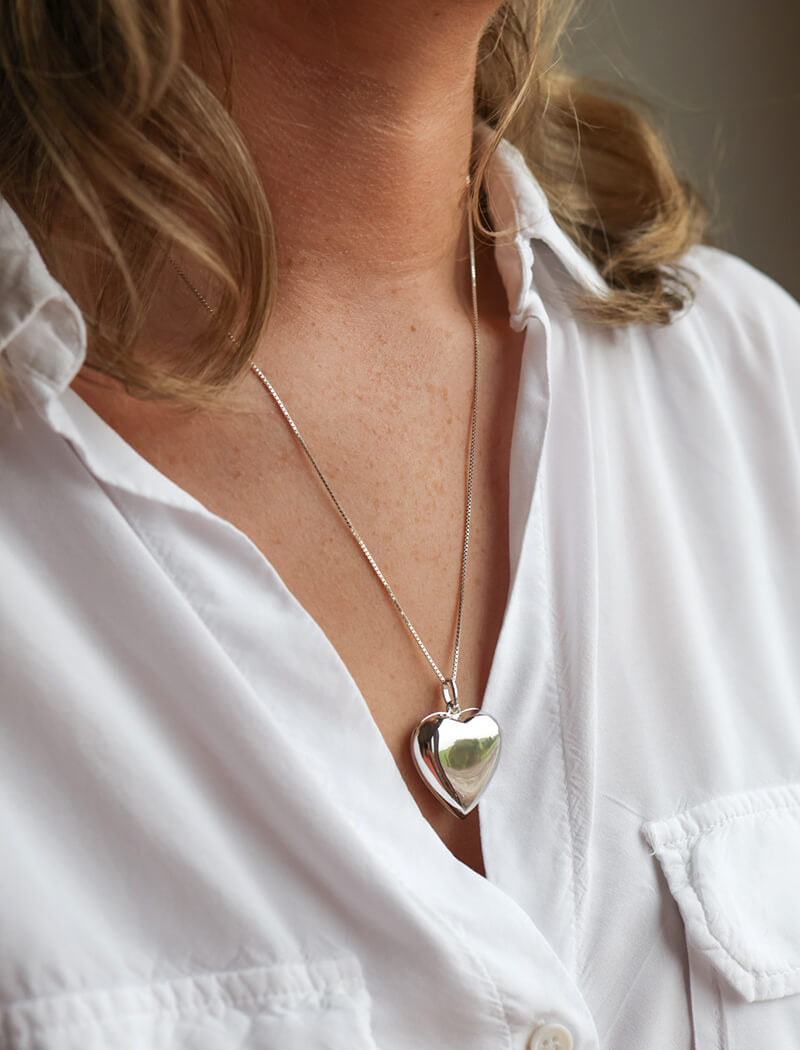 Model wearing a heart shaped photo locket necklace and a white shirt