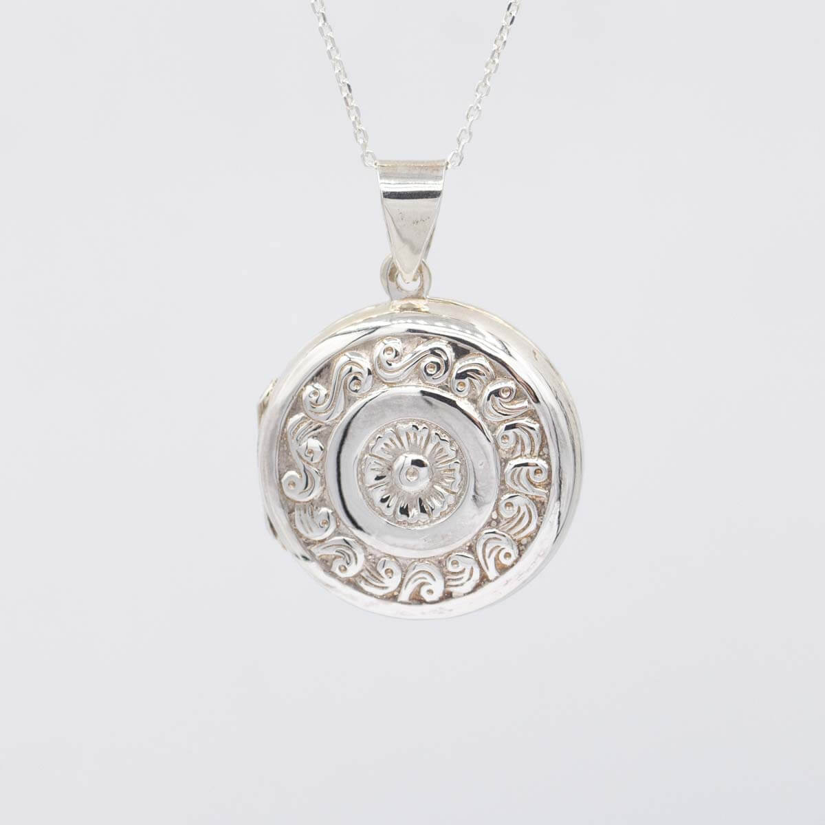 Large silver locket against a white background