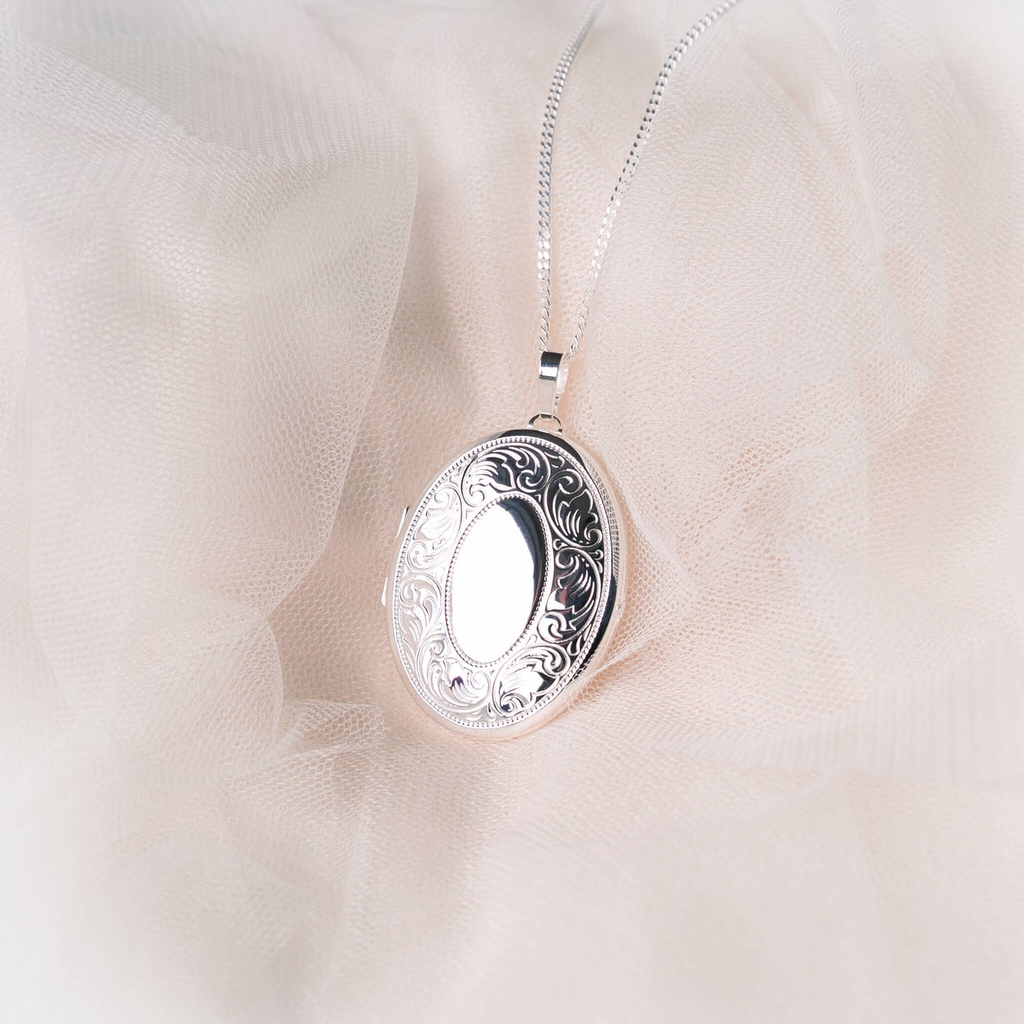 Extra large silver locket on a pink background