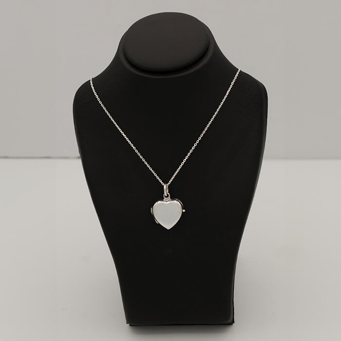 sterling silver heart shaped locket on a black bust