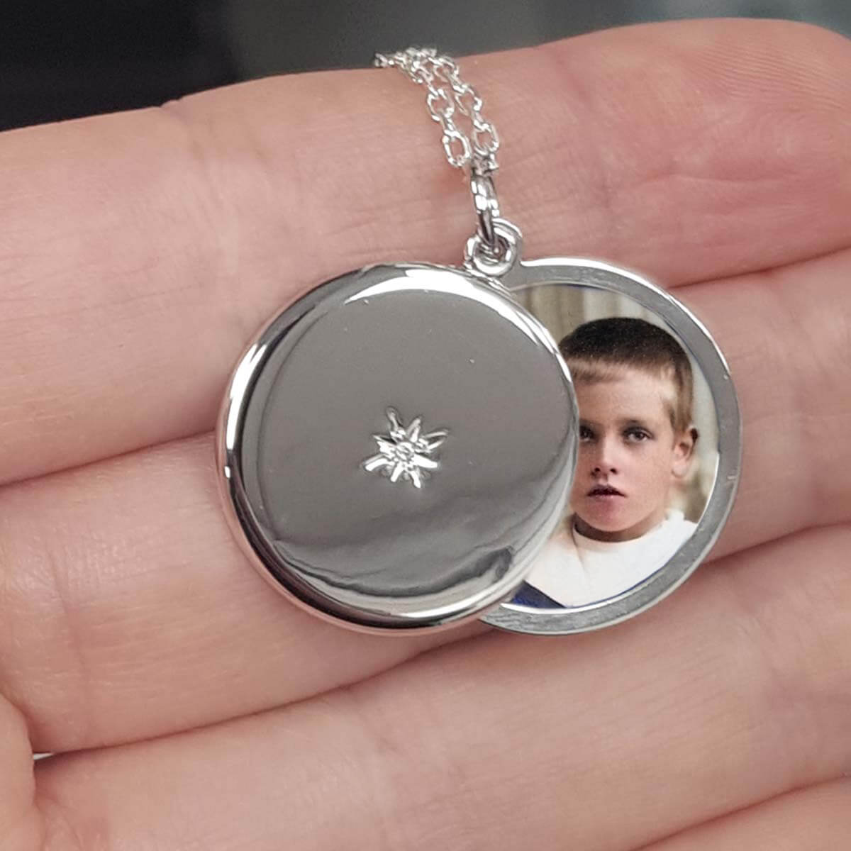 round photo locket in a hand containing a photo of a young boy
