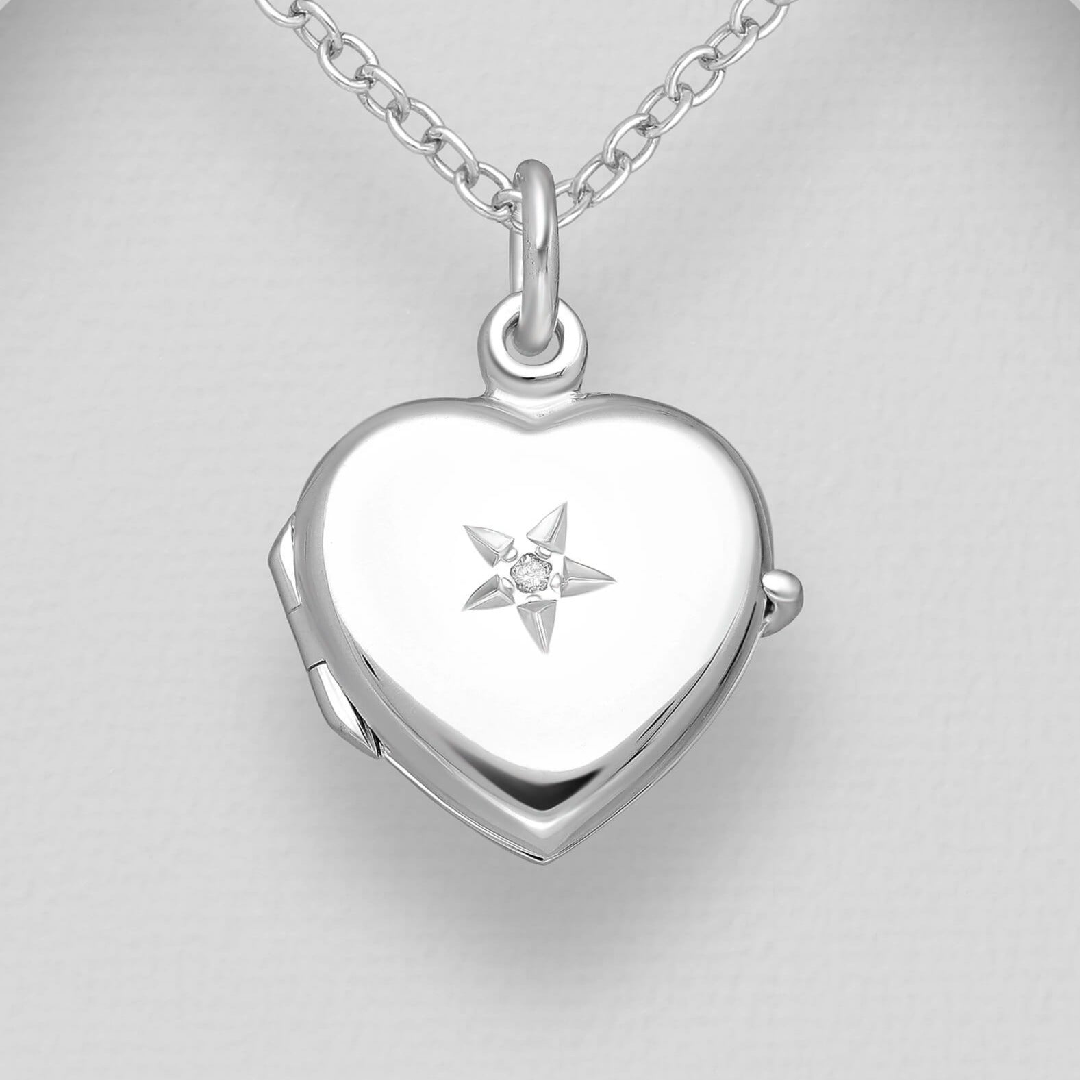 Heart shaped silver locket with star embellishment and white diamond