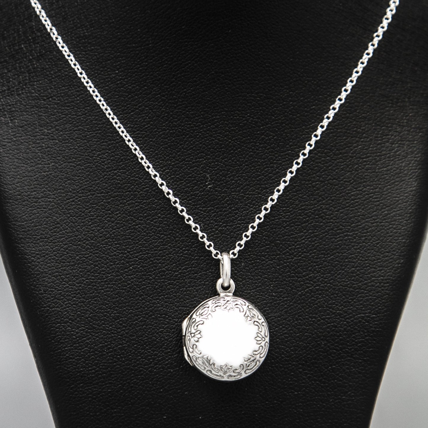Front on view of round silver photo locket and silver chain