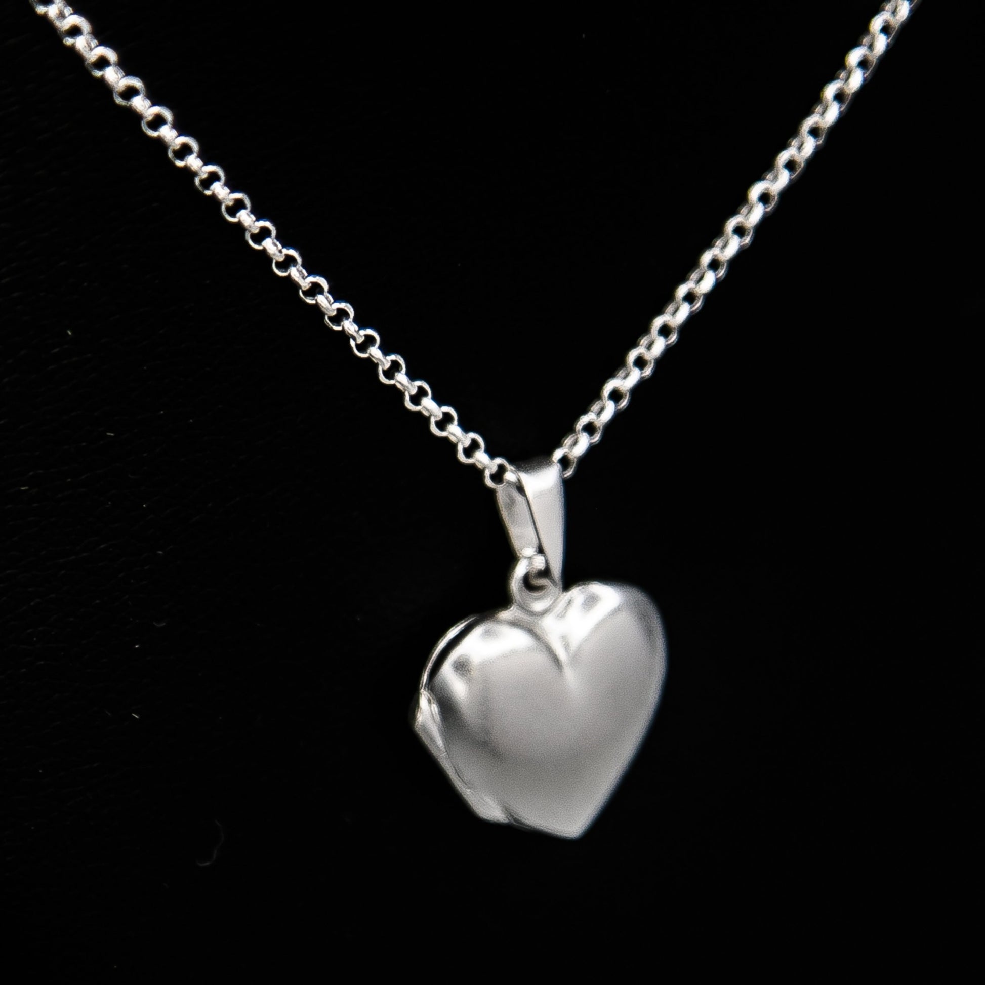 Silver heart shaped photo locket necklace on Italian silver chain against black background