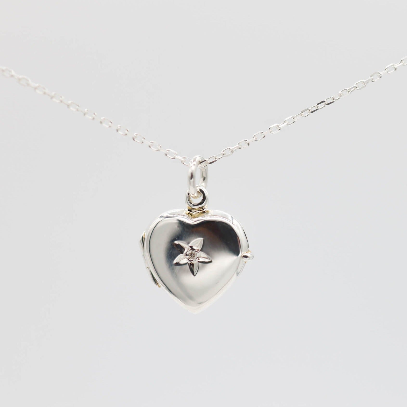 Heat shaped photo locket made from sterling silver on a white background