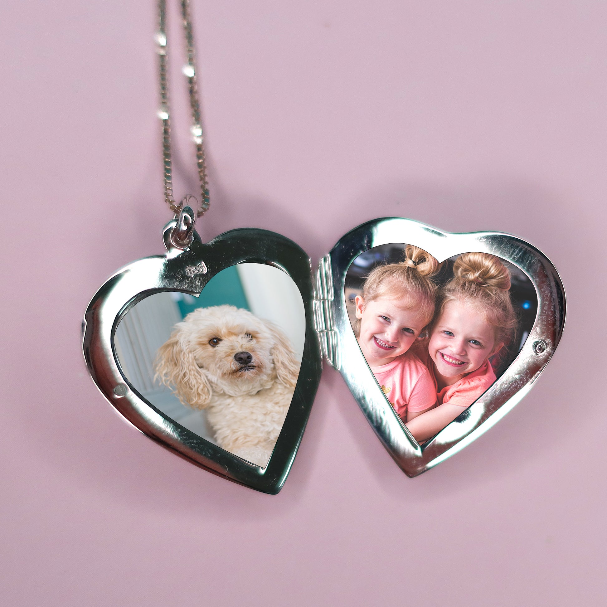 heart shaped locket showing photos of two little girls and dog
