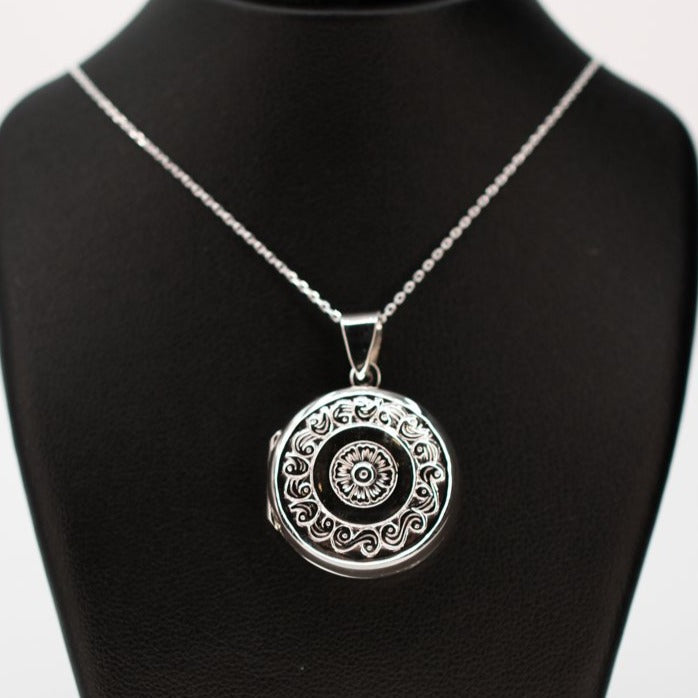 Large silver locket on a silver chain.