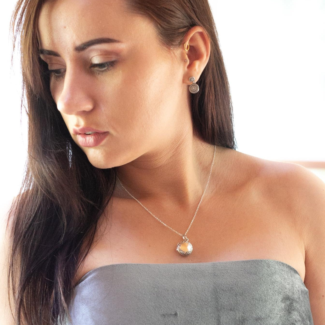 Model wearing grey tube top and round silver photo locket with italian silver chain.