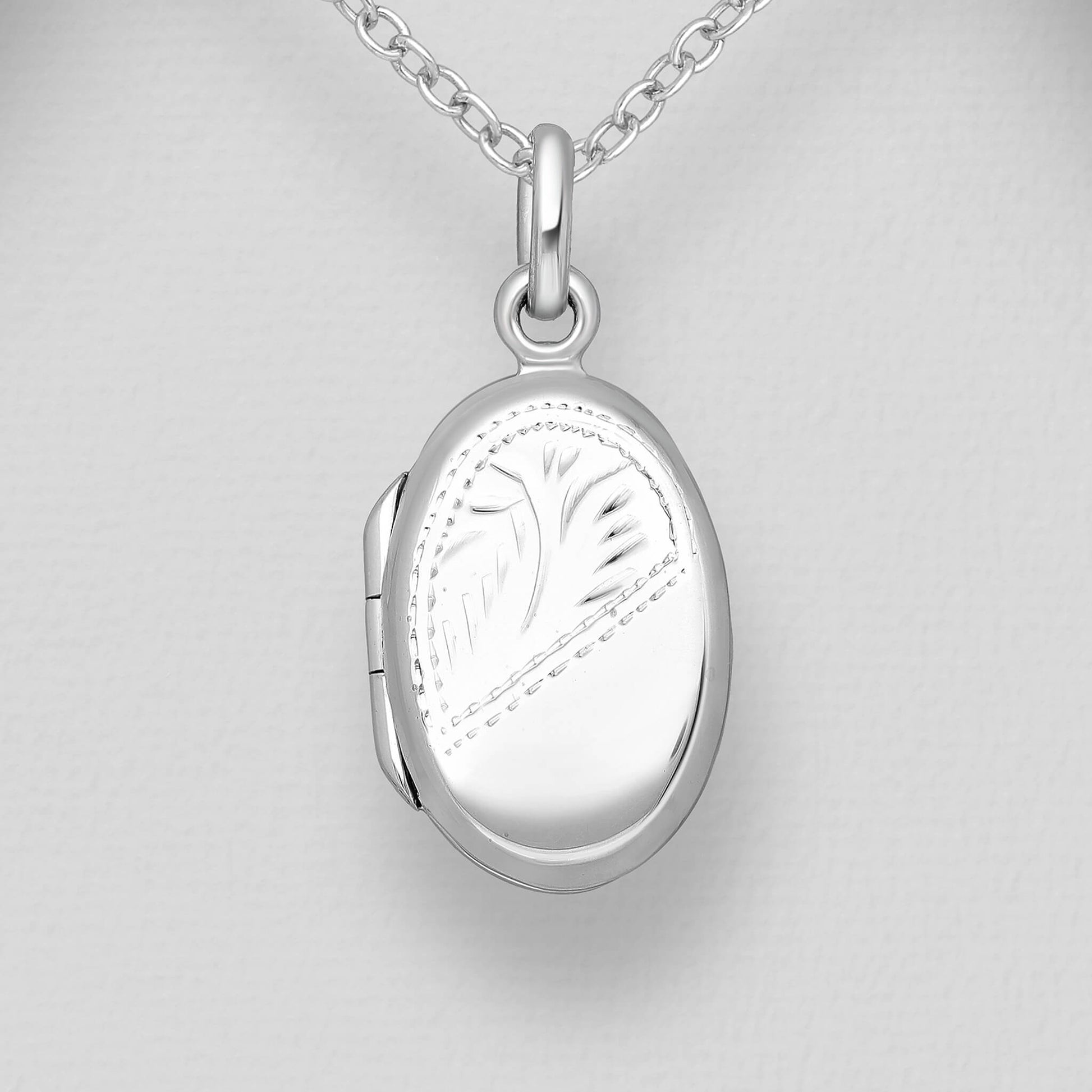 oval sterling silver locket with photos and with chain on white background