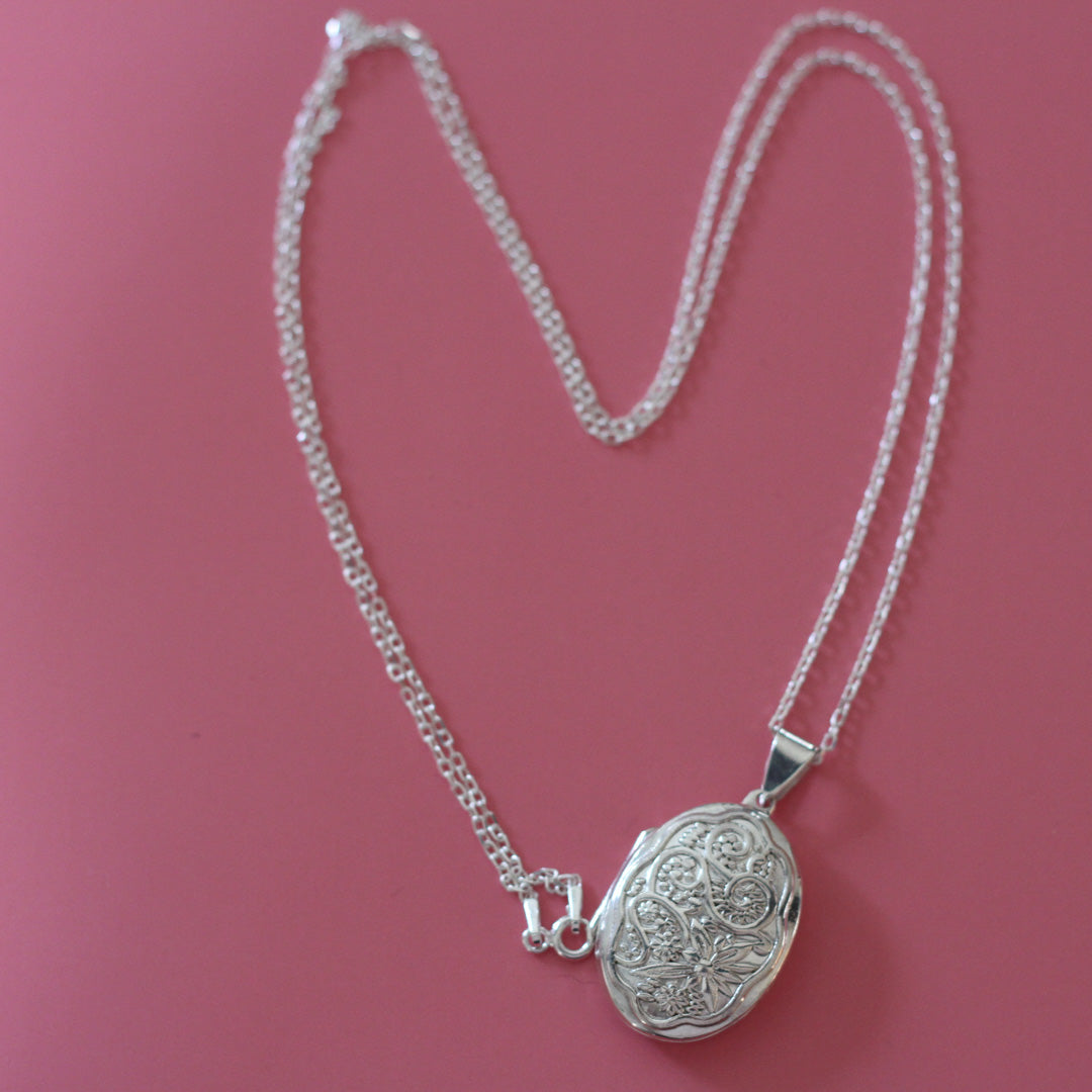 Ornate Oval locket necklace on a pink background