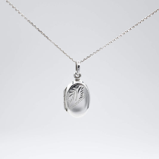 Oval silver locket with photos and silver chain on a white background